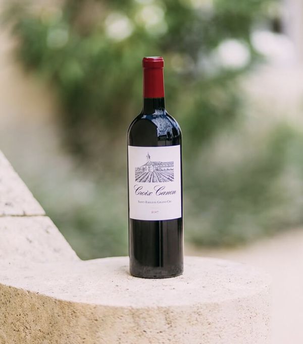 Bouteille de vin Château Canon posée sur un muret