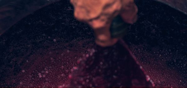 Gros plan d'une main qui touche du vin