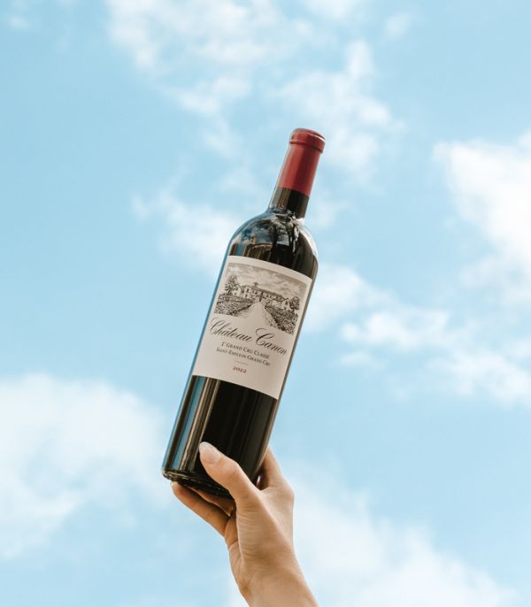 Bouteille de vin rouge Château Canon tenue par une main